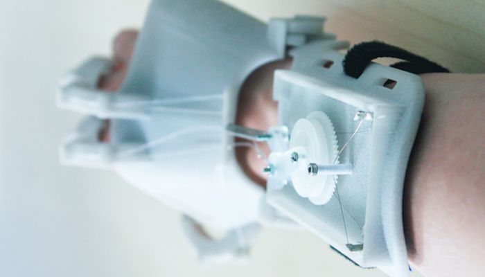 A stepper motor and wires assist the hand’s movements.