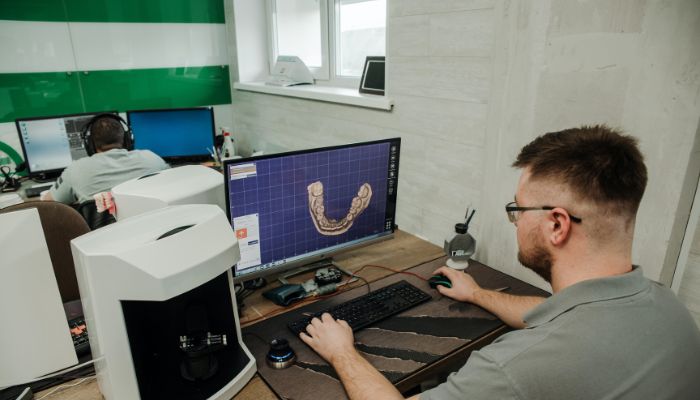 مردی که در رایانه کار می کند به مدل سه بعدی نگاه می کند 