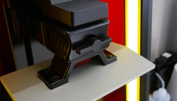 The DF2+'s print bed locks automatically, but a key included with the printer also allows manual control.