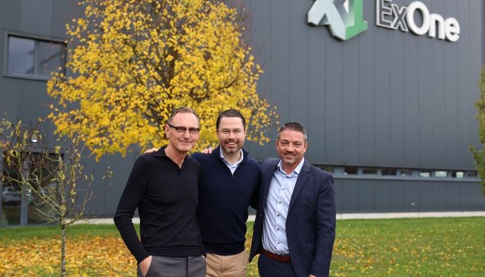 Rudolf Franz, Whitney Haring-Smith, and Eric Bader in front of Exone building