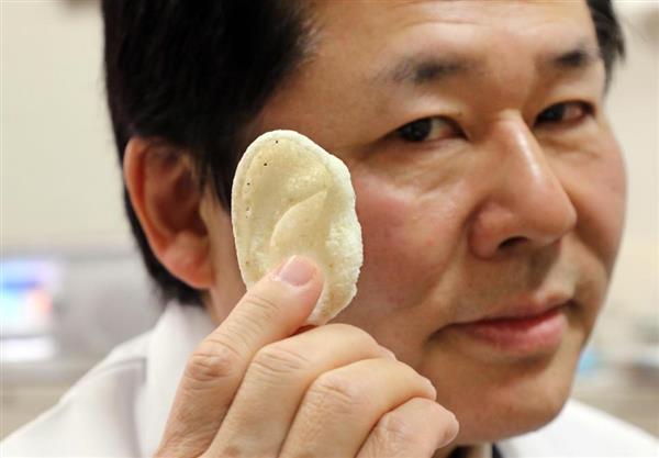 Le Pr. Tsuyoshi Takato de l'université de Tokyo tient une oreille imprimée en 3D